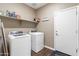 Bright laundry room with modern washer and dryer and a door to the outside at 18382 N Arbor Dr, Maricopa, AZ 85138