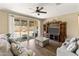 Bright living room features a ceiling fan, tile flooring, and a sliding glass door leading to the backyard at 18382 N Arbor Dr, Maricopa, AZ 85138