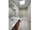 Well-lit bathroom with patterned floors, a skylight, and a shower-tub combination at 18608 N 4Th Ave, Phoenix, AZ 85027