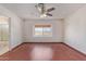 Spacious bedroom showcasing a large window with scenic views, wood floors, and ceiling fan at 18608 N 4Th Ave, Phoenix, AZ 85027