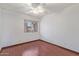 This bedroom features hardwood floors, a ceiling fan, and a window with bright, natural light at 18608 N 4Th Ave, Phoenix, AZ 85027