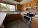 Kitchen with wooden cabinetry, stainless steel stove, white countertops, and a view to the backyard at 18608 N 4Th Ave, Phoenix, AZ 85027