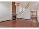 Bright living room with a fireplace, ceiling fan, and dark wood-look flooring under the staircase at 18608 N 4Th Ave, Phoenix, AZ 85027