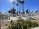 Community pool area featuring a white fence, sun loungers, and palm trees against a clear blue sky at 18608 N 4Th Ave, Phoenix, AZ 85027