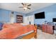 Blue bedroom with a wooden bed, bookshelf, and tv at 2013 E Dust Devil Dr, San Tan Valley, AZ 85143