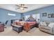 Blue bedroom featuring a wooden bed frame, leather chest, and recliner at 2013 E Dust Devil Dr, San Tan Valley, AZ 85143