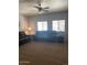 Spacious living room with a ceiling fan and ample natural light from large windows at 2013 E Dust Devil Dr, San Tan Valley, AZ 85143