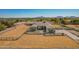 Aerial view of a home with a well-kept lawn and desert landscaping, framed by open fields and mountains at 21717 W South Mountain Ave, Buckeye, AZ 85326