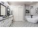 Elegant bathroom features dual sinks, freestanding tub, and glass enclosed shower with decorative tile at 21717 W South Mountain Ave, Buckeye, AZ 85326