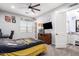 Spacious bedroom with ceiling fan, desk, tv, and a view of a tastefully decorated bathroom at 21717 W South Mountain Ave, Buckeye, AZ 85326