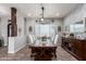 Dining room boasts rustic wood table, upholstered chairs, decorative wall art, and designer light fixture at 21717 W South Mountain Ave, Buckeye, AZ 85326