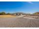 Long driveway leads to an attached garage; desert landscaping and full fencing throughout the property at 21717 W South Mountain Ave, Buckeye, AZ 85326