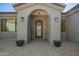 Inviting front entrance with an arched doorway, decorative wreath, and well-maintained landscaping at 21717 W South Mountain Ave, Buckeye, AZ 85326