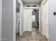 Hallway view leading to a bright home office featuring wood-style flooring and neutral wall colors at 21717 W South Mountain Ave, Buckeye, AZ 85326