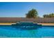 Backyard swimming pool featuring a tiled waterfall feature at 21717 W South Mountain Ave, Buckeye, AZ 85326