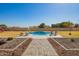 Backyard swimming pool with a built-in waterfall feature, surrounded by landscaping and lounge chairs at 21717 W South Mountain Ave, Buckeye, AZ 85326