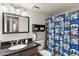 This bathroom includes a granite countertop, framed mirror, and quirky shower curtain at 222 W Brown Rd # 57, Mesa, AZ 85201