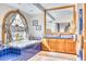 Bathroom showcasing a luxurious soaking tub surrounded by blue tile work and a sunny arched window at 2233 N 9Th Ave, Phoenix, AZ 85007