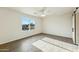 Spacious bedroom with wood-look tile flooring, a ceiling fan, and a large window offering natural light at 24942 S 190Th Dr, Buckeye, AZ 85326