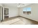 Bedroom with wood-look tile flooring, ceiling fan, and ample natural light at 24942 S 190Th Dr, Buckeye, AZ 85326