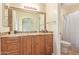 Bathroom featuring an expansive wood vanity, granite counters, framed mirror, and shower at 2625 W Oakland St, Chandler, AZ 85224