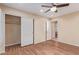 Bright bedroom with wood-look flooring, closet, ceiling fan, and access to en suite bathroom at 2625 W Oakland St, Chandler, AZ 85224