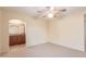 Neutral carpeted bedroom with open bathroom access and lighted ceiling fan at 2625 W Oakland St, Chandler, AZ 85224