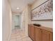 Inviting hallway featuring tile flooring and a built in wooden cabinet with decorative art at 2625 W Oakland St, Chandler, AZ 85224