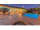 Twilight shot of a large pool with backyard views and a cozy fire pit at 2625 W Oakland St, Chandler, AZ 85224