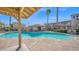 Community swimming pool with lounge chairs and umbrellas at 2821 S Skyline Dr # 149, Mesa, AZ 85212