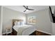 Cozy bedroom featuring a ceiling fan, wood floors, and a serene view from the window at 3119 E Rosemonte Dr, Phoenix, AZ 85050