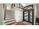 Elegant foyer with hardwood floors, a staircase with white risers and wood treads, and a decorative front door at 3119 E Rosemonte Dr, Phoenix, AZ 85050