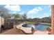 Stunning backyard pool area with rock features, a built-in fire pit, and ample lounge seating at 3119 E Rosemonte Dr, Phoenix, AZ 85050