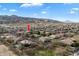 Aerial shot over neighborhood with arrow indicating specific property among houses with pools and landscaping near mountains at 3132 E Harwell Rd, Phoenix, AZ 85042