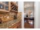 Bar area with wine rack, glassware storage, and granite countertop at 3132 E Harwell Rd, Phoenix, AZ 85042