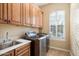 Functional laundry room equipped with modern appliances, ample counter space, and custom cabinets at 3132 E Harwell Rd, Phoenix, AZ 85042