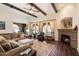 Inviting living room featuring a stone fireplace, wood floors, large windows, and comfortable seating at 3132 E Harwell Rd, Phoenix, AZ 85042