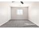 Bedroom with neutral walls and carpet, ceiling fan, window, and a white door at 32815 N Slate Creek Dr, San Tan Valley, AZ 85143