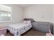 Cozy bedroom featuring a padded headboard, dresser, and a window at 35374 W San Sisto Ave, Maricopa, AZ 85138