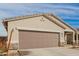 Exterior showing a close-up of a two-car garage with stucco siding and stone accents at 35374 W San Sisto Ave, Maricopa, AZ 85138