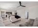 Spacious living room with neutral tones, ceiling fan, and open floor plan leading to the kitchen and dining area at 35374 W San Sisto Ave, Maricopa, AZ 85138