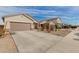 Residential street view with several houses in the neighborhood and a long concrete driveway at 35374 W San Sisto Ave, Maricopa, AZ 85138