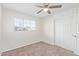 This bedroom features a carpeted floor, a closet, a window with blinds, and a ceiling fan at 3611 W Hazelwood St, Phoenix, AZ 85019