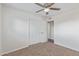 This bedroom features a ceiling fan, carpet, and a closet with an open door into another room at 3611 W Hazelwood St, Phoenix, AZ 85019