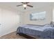 This carpeted bedroom features a ceiling fan, a window for natural light, and a closet for storage at 3611 W Hazelwood St, Phoenix, AZ 85019