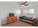 This carpeted bedroom features a ceiling fan, a window for natural light, a bed, and a dresser at 3611 W Hazelwood St, Phoenix, AZ 85019