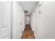 Long hallway with wood look tile flooring, white walls, and closet space at 3611 W Hazelwood St, Phoenix, AZ 85019