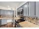 Kitchen with stainless steel appliances, modern cabinets, and tile countertops at 3611 W Hazelwood St, Phoenix, AZ 85019