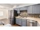 Modern kitchen with stainless steel appliances and grey cabinets at 3611 W Hazelwood St, Phoenix, AZ 85019