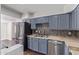 Well-equipped kitchen featuring blue cabinets, stainless steel appliances, and tile backsplash with hardwood floors at 3611 W Hazelwood St, Phoenix, AZ 85019